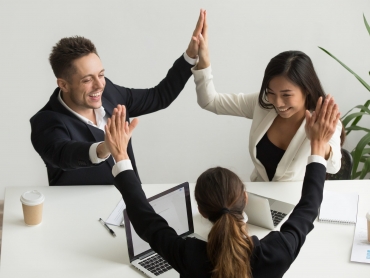 Excited multiracial team giving high five together celebrating victory business success, happy motivated diverse colleagues join palms promising good relations unity, engaging in teambuilding concept